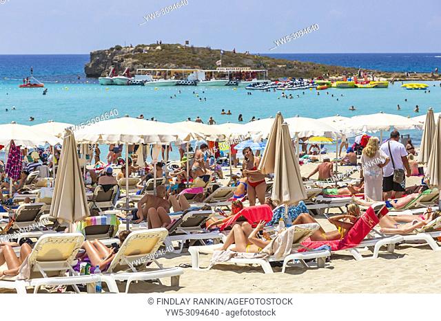 Tourists sunbathing on the beach at Nissi Bay near Ayia Napa, Cyprus