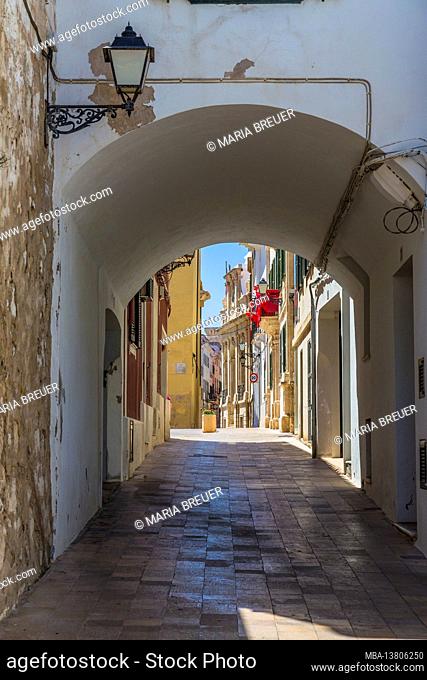Narrow alley with arch, balcony decorated with red at the back, Can Mercadal, city library, Biblioteca Central Insular, Placa de la Conquesta, Mahon, Mao