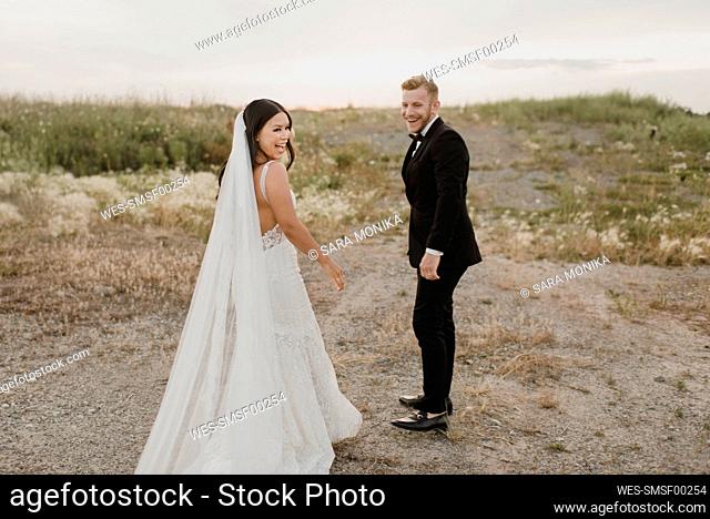 Smiling bridegroom standing in field