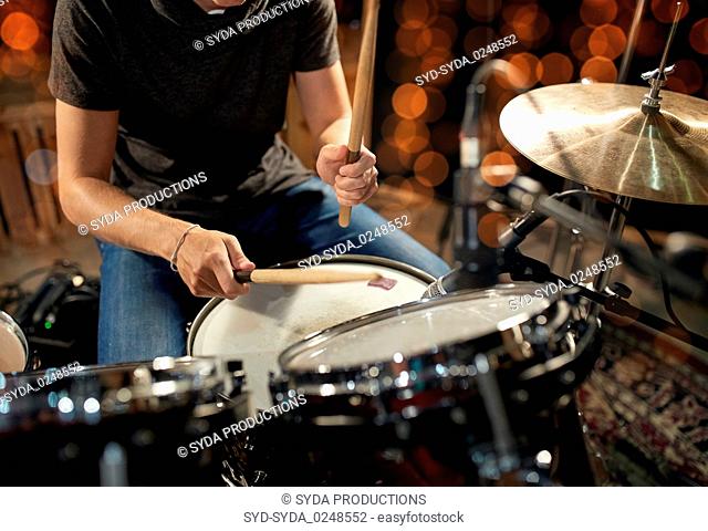 male musician playing drum kit at concert