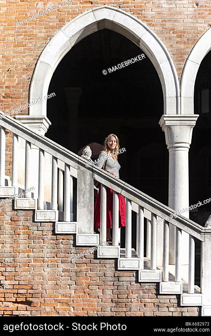 Young woman walking down a staircase, Mercato di Rialto, Venice, Veneto, Italy, Europe