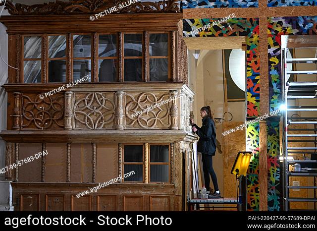 25 April 2022, Saxony-Anhalt, Halle (Saale): Milena Deutsch is repairing defective parts. The ornate wooden elements are restored piece by piece