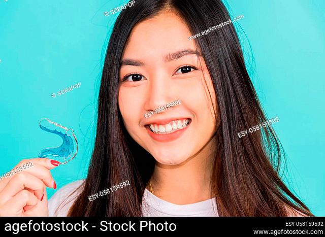 Portrait young Asian beautiful woman smiling holding silicone orthodontic retainers for teeth, Teeth retaining tools after removable braces
