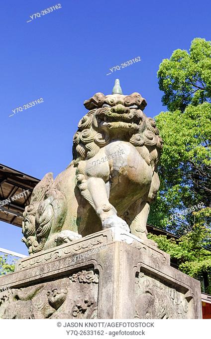 A stone lion-dog guardian, one of a pair guarding the entrance to the Yasaka Shrine, Kyoto, Kansai, Japan
