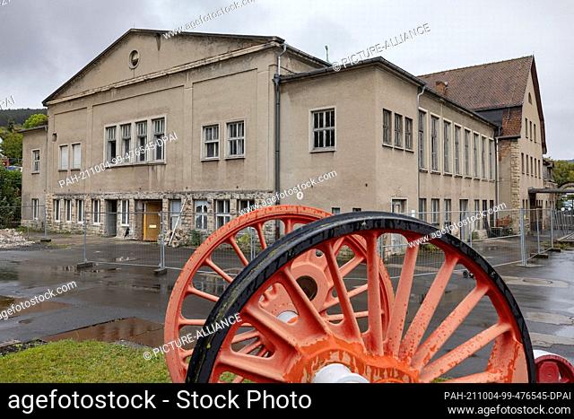 04 October 2021, Thuringia, Meiningen: The axle of a steam locomotive stands in front of a building in which the ""Steam Locomotive World Meiningen"" is to be...