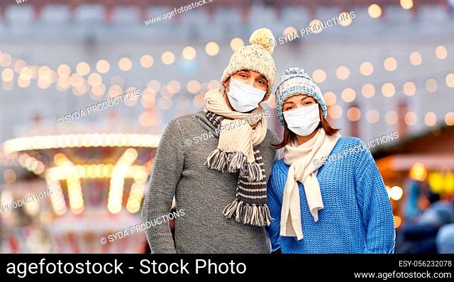 couple in masks and winter clothes on christmas