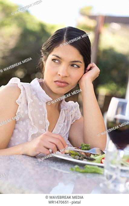 Annoyed woman eating a salad