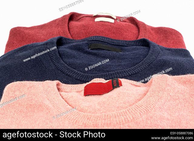three colored wool shirtson a white table