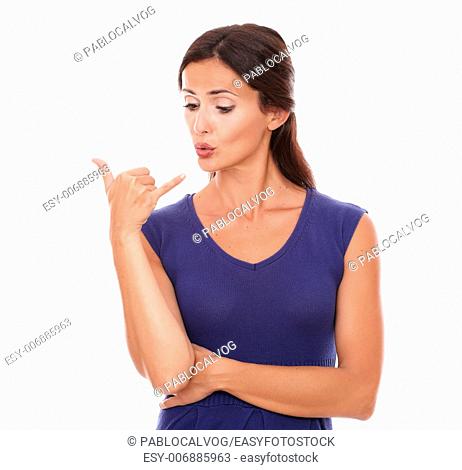 Beautiful young girl gesturing a phone call while looking at her hand in white background