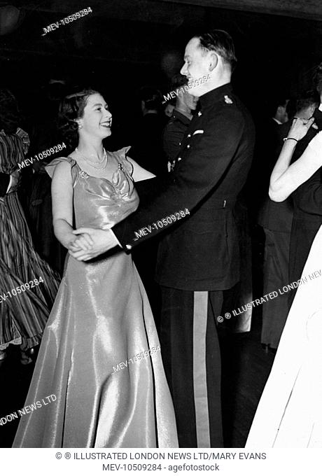 Princess Elizabeth (Queen Elizabeth II) attending a ball held at the Old House Hotel in aid of the NSPCC. She is pictured smiling as she dances with Captain...