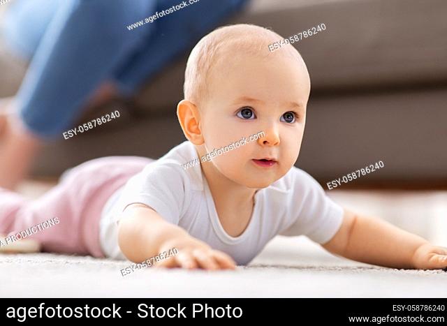 little baby girl crawling on floor at home