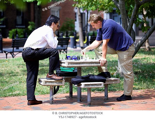 Men playing chess during lunch break in an outdoor park table - Washington, DC