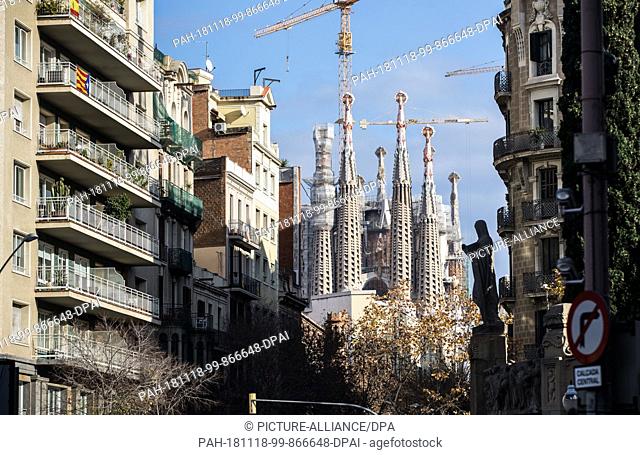 20 December 2017, Spain, Barcelona: View of the cathedral Sagrada Familia between the houses, a Roman Catholic basilica in district Eixample