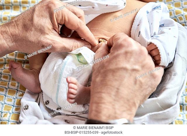 Reportage on a midwife in Lyon, France. Checking a 7-day old baby's cord