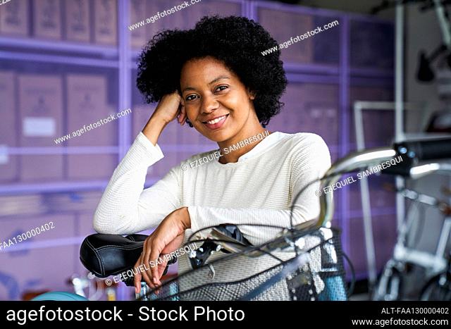 Mid-shot portrait of African-American woman standing in her bicycle shop