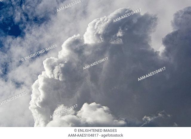 Expanding Cumulus strong Storm Clouds expanding in Air below higher Cirrus Clouds, California