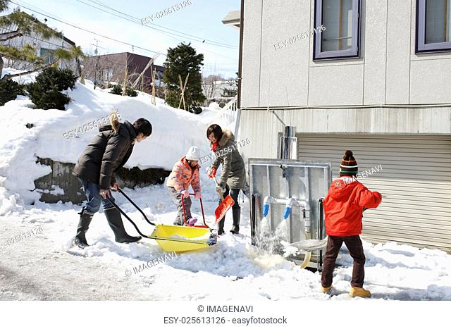 Family removing snow