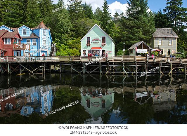 Houses along boardwalk of Creek Street the former Red Light district in Ketchikan reflecting in water at high tide, Southeast Alaska, USA