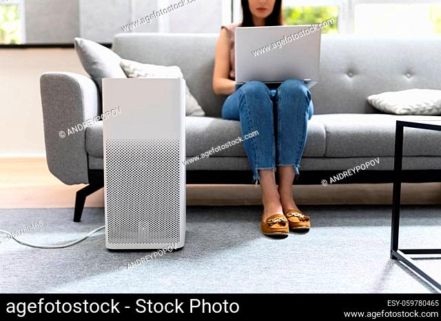 Woman In Living Room Using Air Cleaner And Humidifier