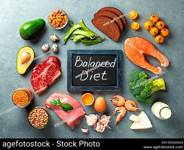 Balanced diet - healthy food on gray stone background. Various food ingredients and chalkboard with words Balanced Diet. Top view or flat lay