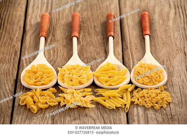 Varieties of pasta spilling out of spoons