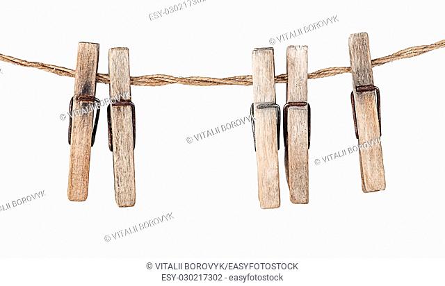 Five old clothespins on rope isolated on white background