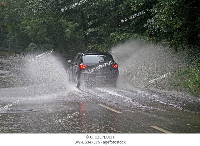 road traffic on flooded road in heavy rain, Germany