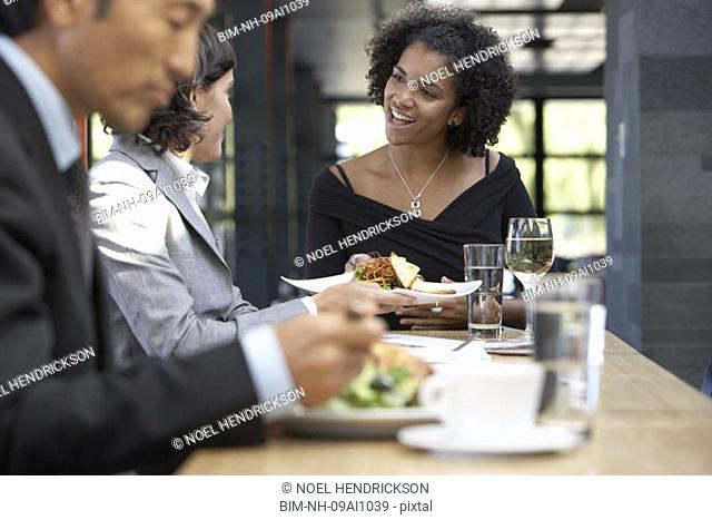 African waitress bringing food to businesswoman