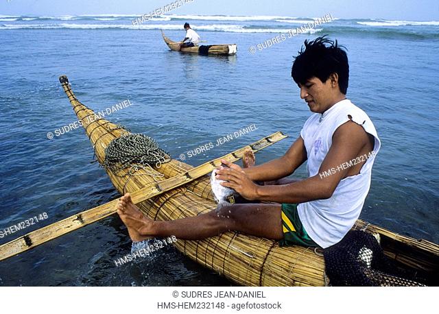 Peru, Lambayeque region, Pimentel, a fisherman sitting on a Caballito de Totora, who brings a fish