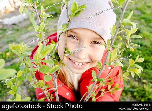 Happy girl with plant at garden
