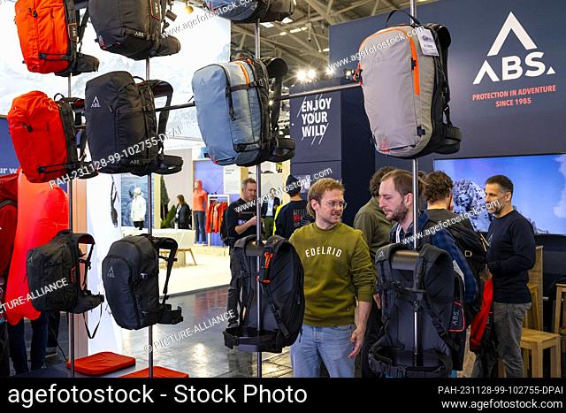 28 November 2023, Bavaria, Munich: Trade fair visitors look at avalanche airbags from the company ""ABS"" during the ISPO sporting goods trade fair at Messe...
