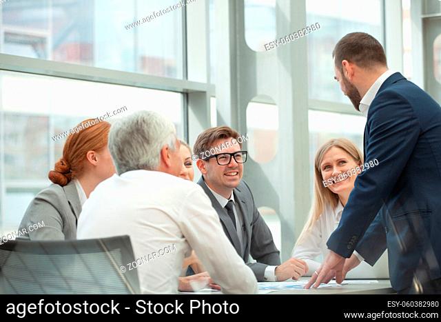 Business team sitting by the table and working smiling with documents in office