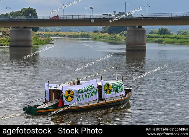 12 July 2021, Brandenburg, Frankfurt (Oder): Members of the Brandenburg Green Youth and Polish Green MPs protest with banners in both languages on a ship on the...