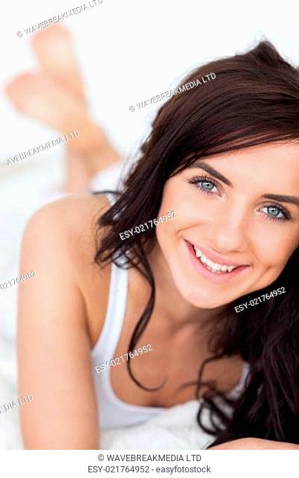 Smiling brunette woman lying on her quilt