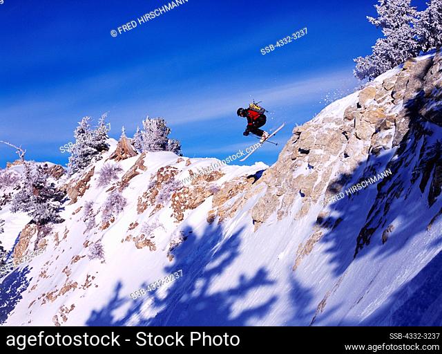 Freestyle alpine extreme skiier Dylan Crossman jumping rocky outcrop at Alta, Little Cottonwood Canyon, Utah