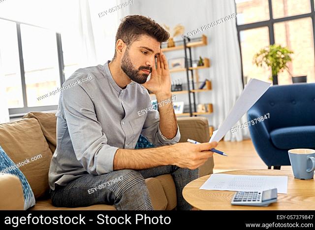 stressed man with bills at home
