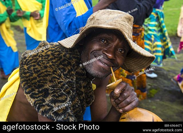 Friendly man drinking local beer at a Ceremony of former poachers, in the Virunga National Park, Rwanda, Africa