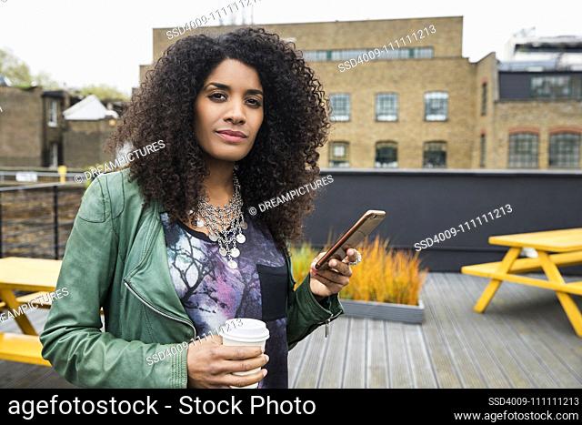 Portrait of Woman on rooftop patio with cell phone