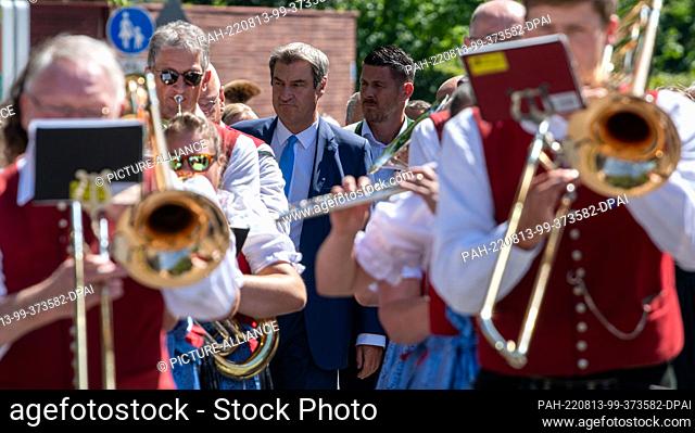 13 August 2022, Bavaria, Kempten: Markus Söder (CSU), Prime Minister of Bavaria, parades through the town with dre Stadtkapelle at the opening of the 71st...