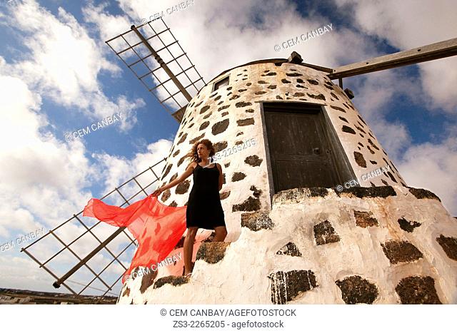 Woman posing in front of the windmill near Tefia, La Oliva, Fuerteventura, Canary Islands, Spain, Europe