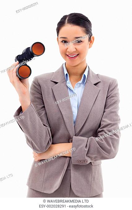 Portrait of a businesswoman holding binoculars against a white background