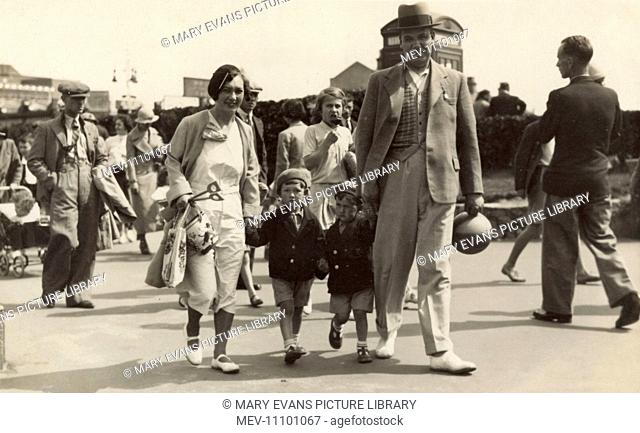A smartly turned out family enjoying a seaside outing in Margate. Mother is fashionably dressed in a white sporty dress with beret and the little boys are...