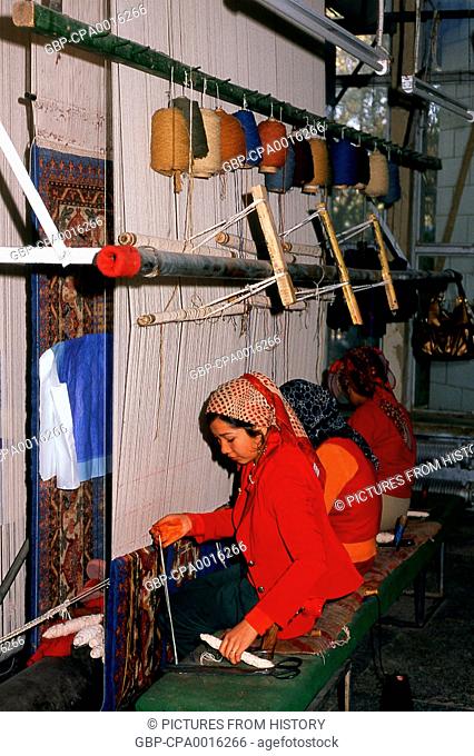 China: Uighur carpet weavers, carpet factory, Khotan, Xinjiang