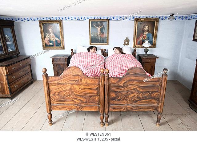 Germany, Bavaria, Young couple lying in bedroom