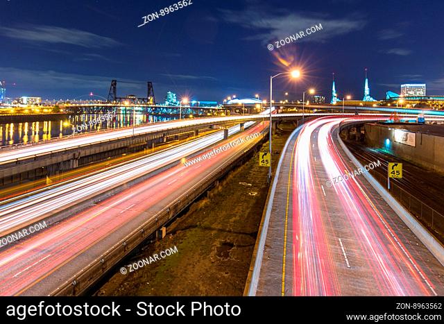 traffic on road with cityscape and skyline of portland at twilight