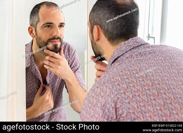 A man looking in a mirror to give him self-confidence