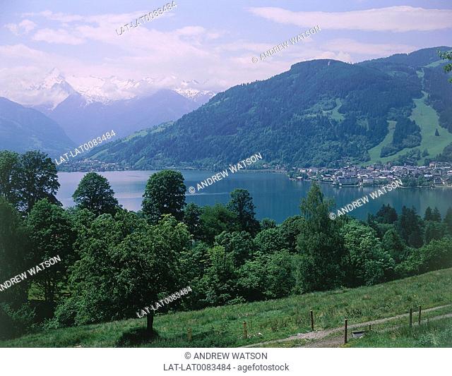 Above Thumersbach. View over lake. Towns of Zell on right and Schuttdorf on left. Mountains. Snow capped