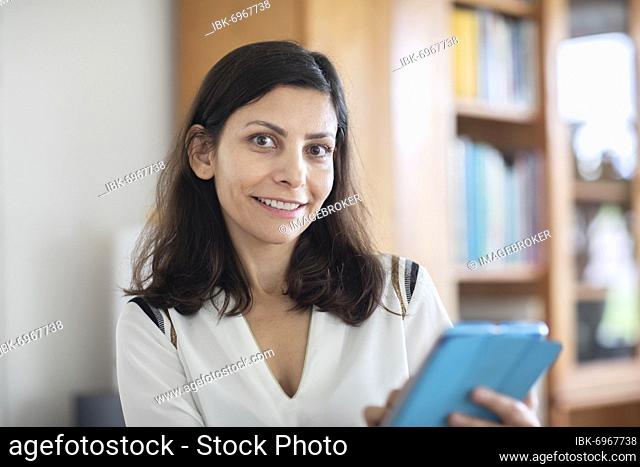 Middle aged serious manager working in an office with tablet, Freiburg, Baden-Württemberg, Germany, Europe