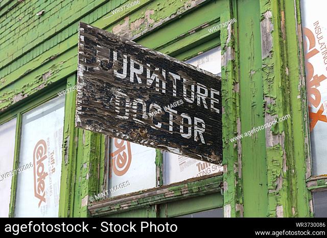 Abandoned building on a main street, Furniture Doctor sign above front door, repair shop