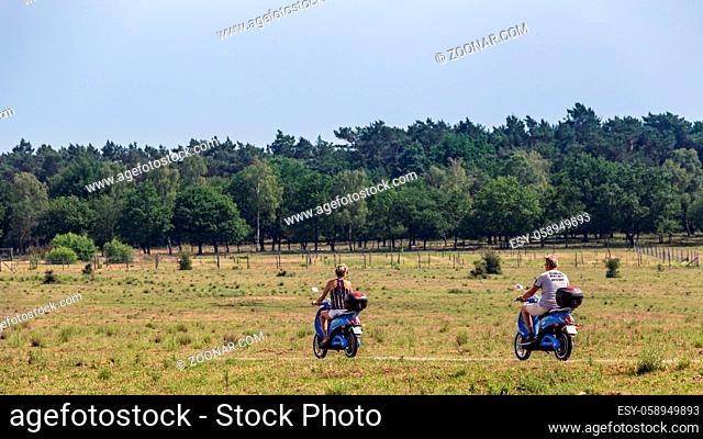 Ede, The Netherlands - June 13, 2020: Tourist exploring nature in national park the Veluwe with an electric scooter in Ede in the Netherlands